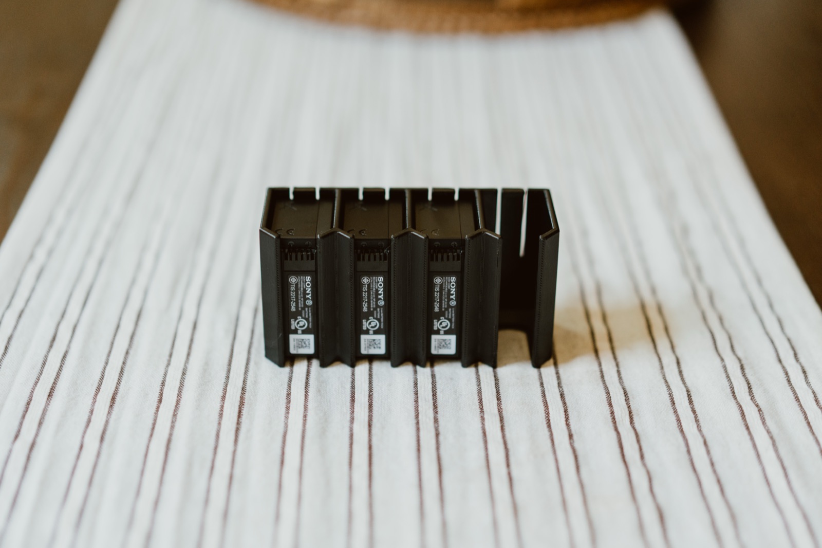 Three Sony NP-SA100 batteries seated in the black four slot holder