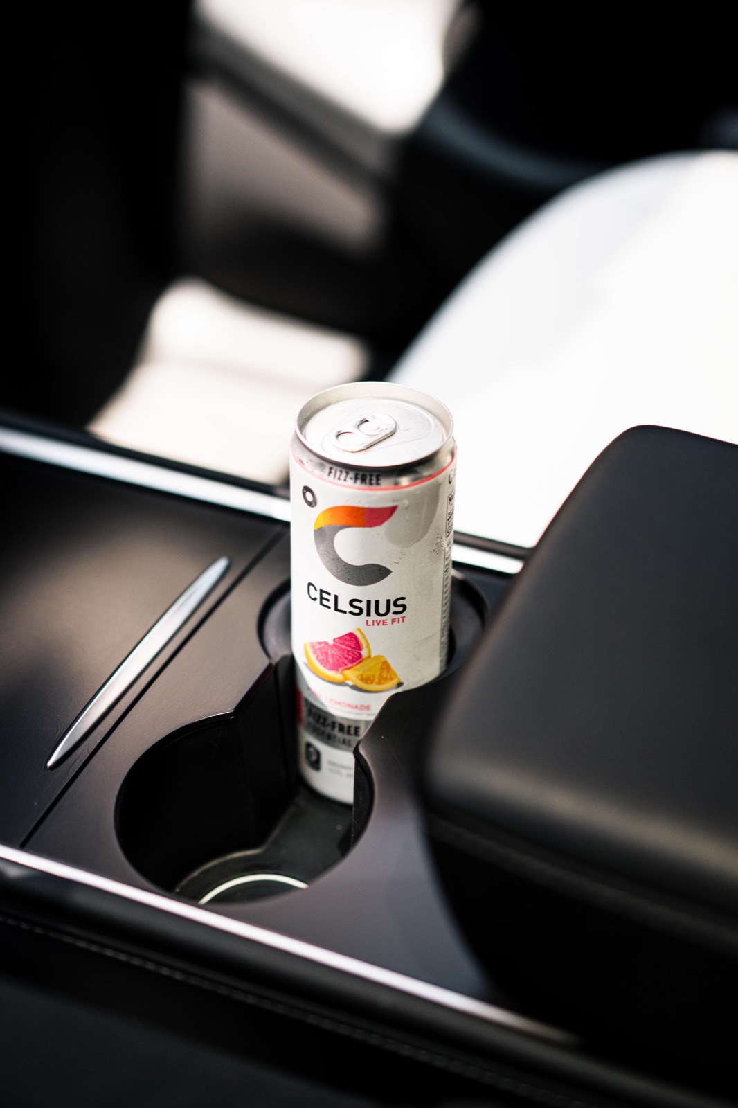 A slim Celsius can held upright in a Tesla Model Y cup holder by the insert